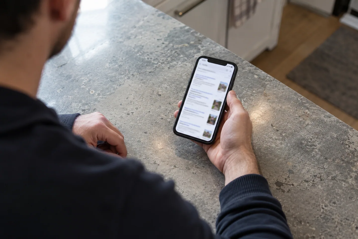 En person ser gjennom søkeresultater på mobiltelefonen.